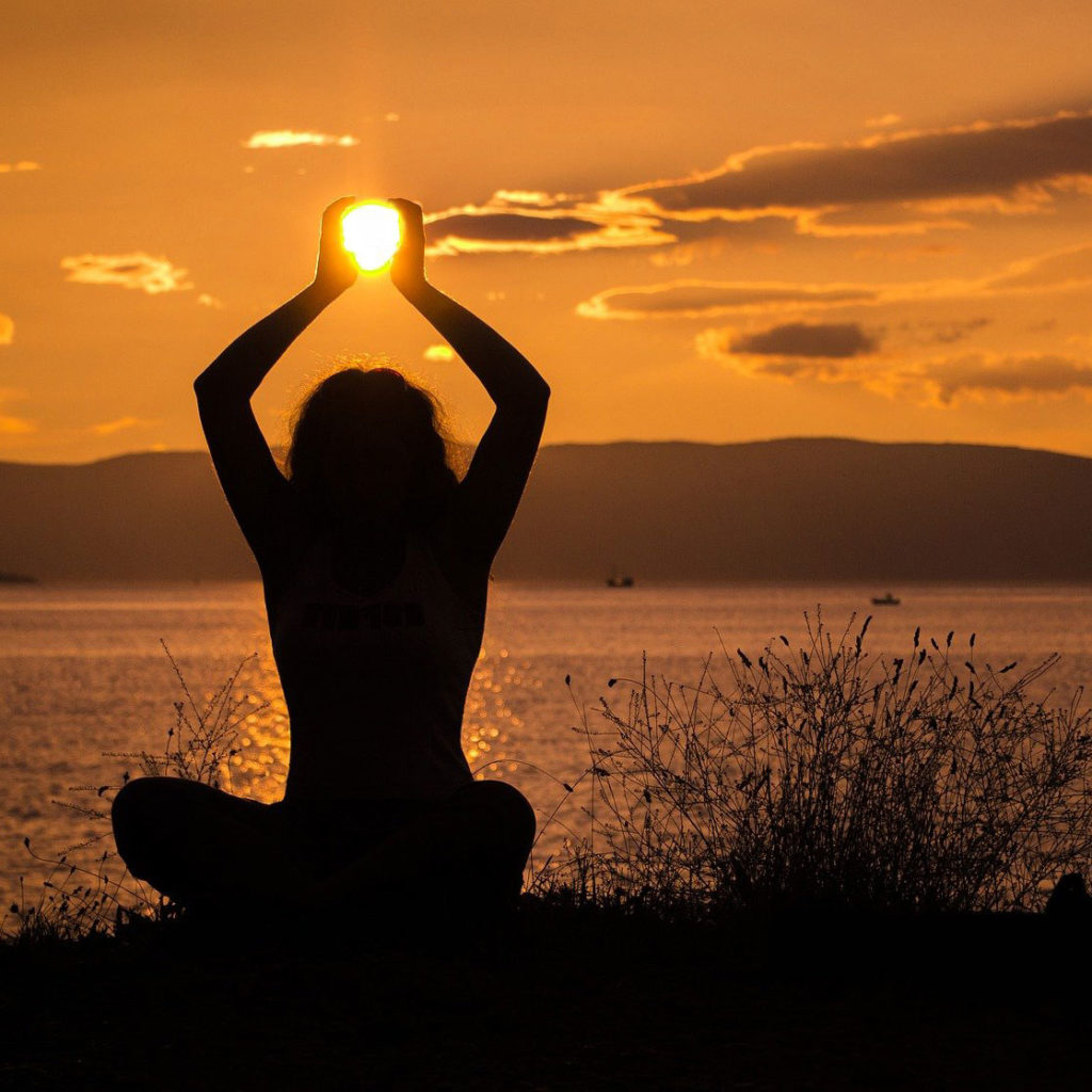 Frau-in-Yoga-Pose-bei-Sonnenuntergang